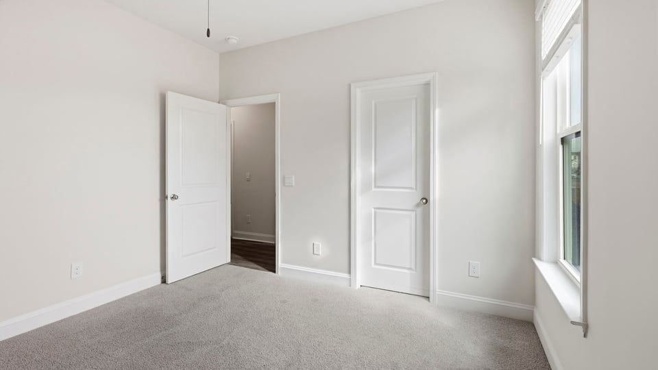Bedroom with carpet and window.