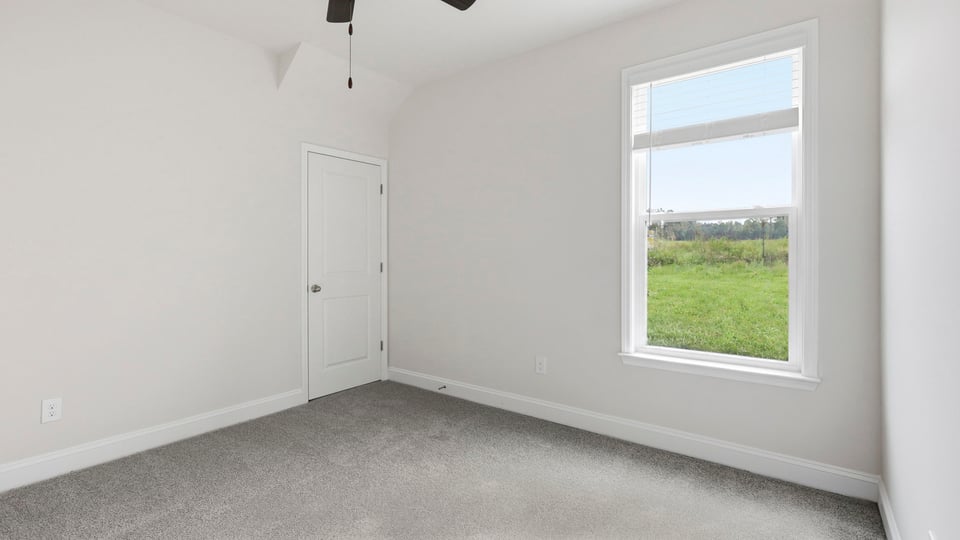 Bedroom with carpet and window.