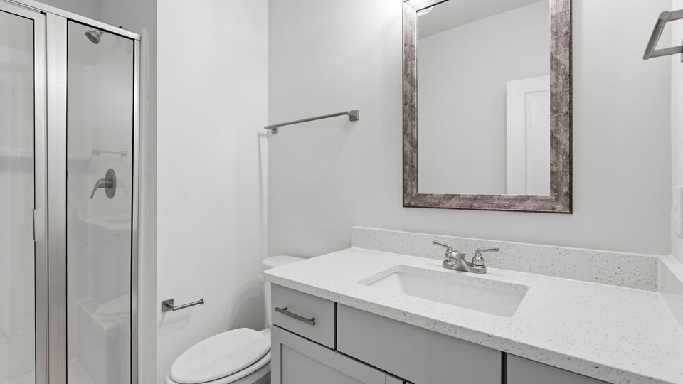 Bathroom with double vanity sink and walk in shower.