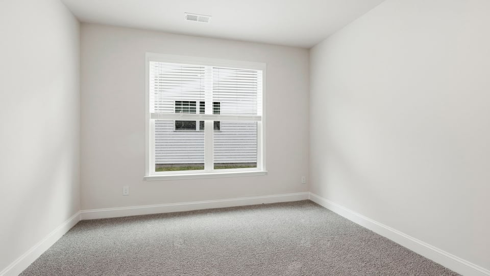 Bedroom with carpet and window.