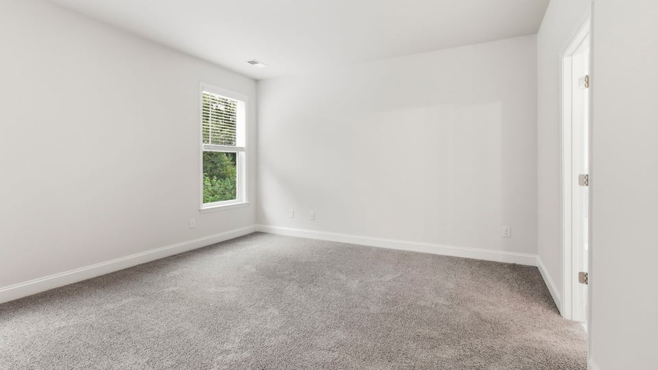 Bedroom with carpet and window.