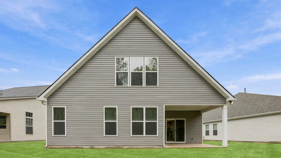 Back exterior of home with large backyard.