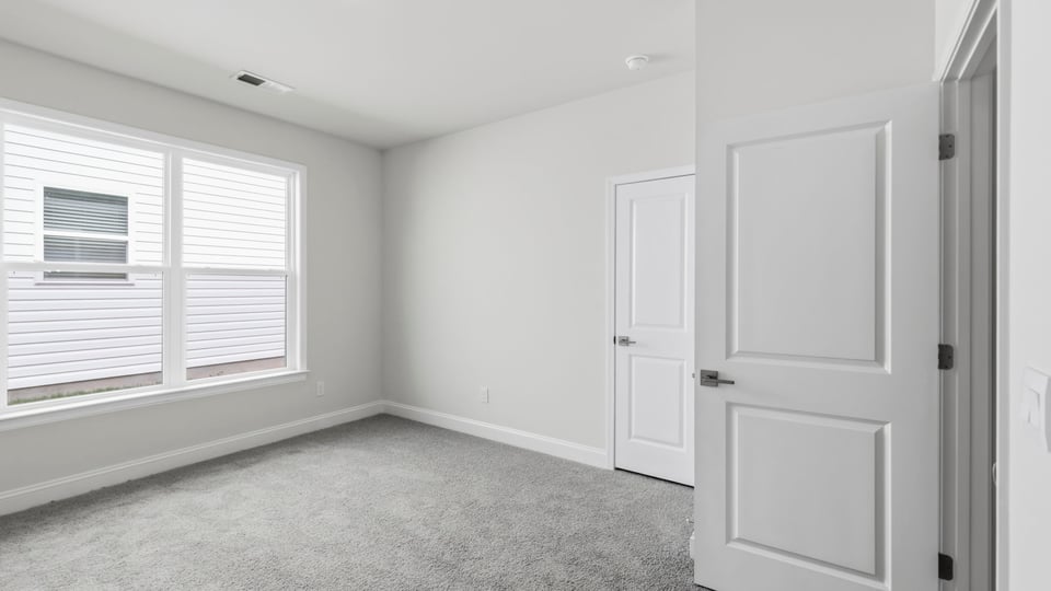 Bedroom with carpet and window.