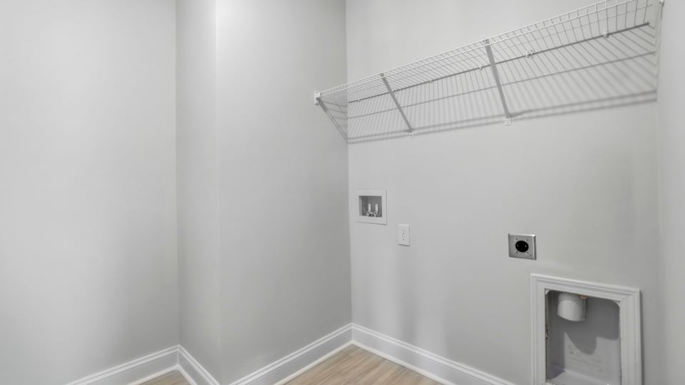 Laundry room with hanging storage racks.