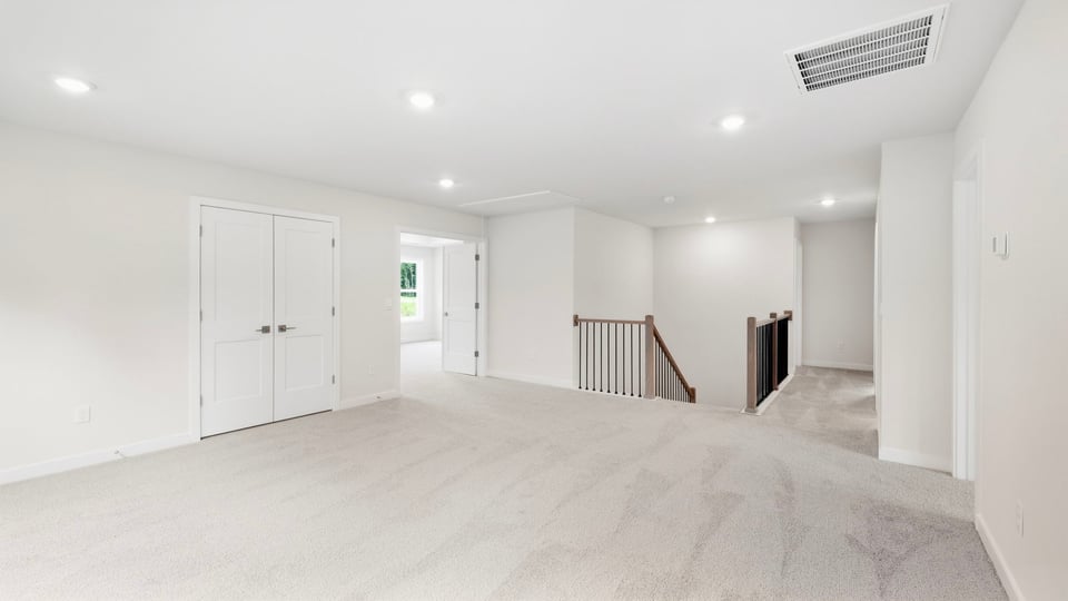 Loft area with windows and carpet.