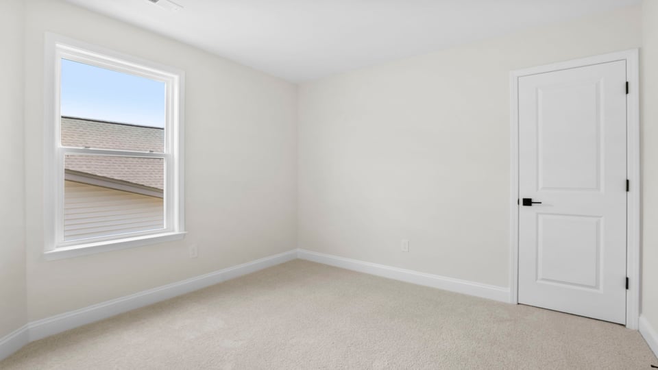 Bedroom with carpet and window.
