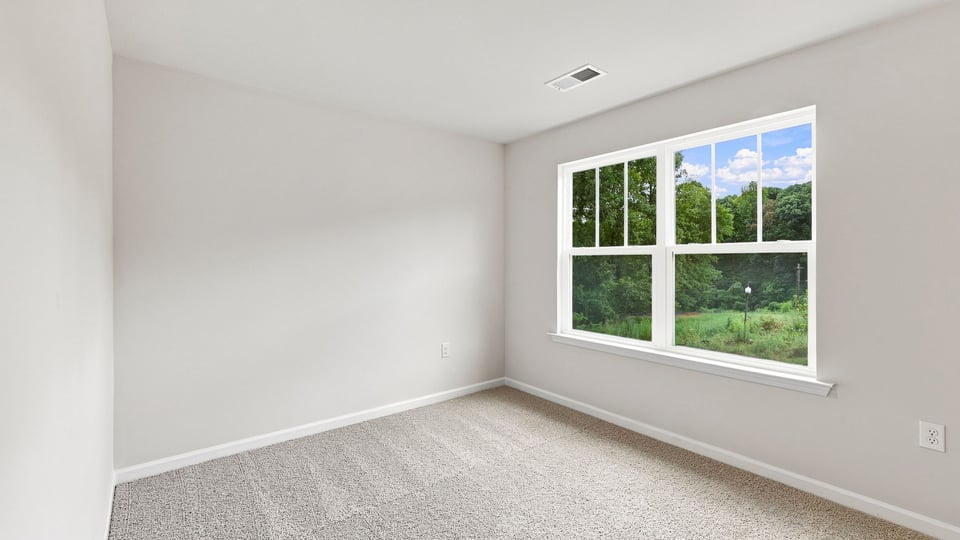 Bedroom with carpet and windows.