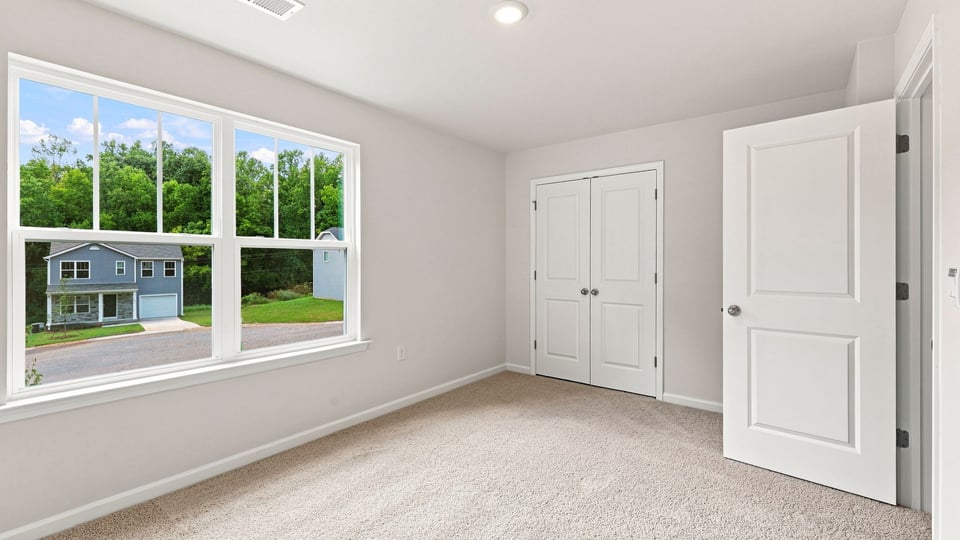 Bedroom with carpet and windows.