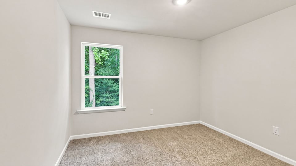 Bedroom with carpet and windows.