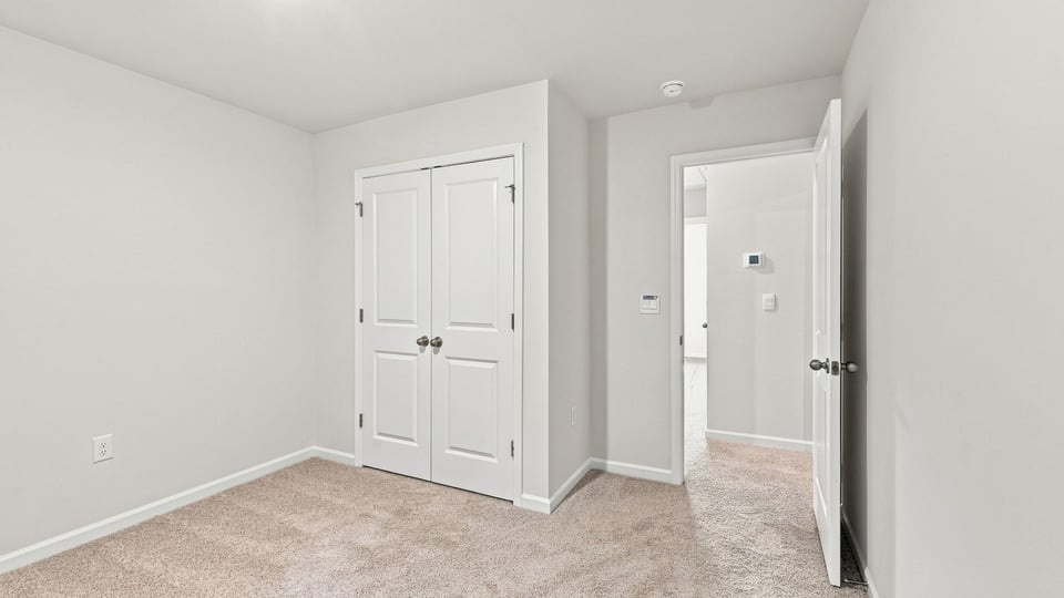 Bedroom with carpet and windows.
