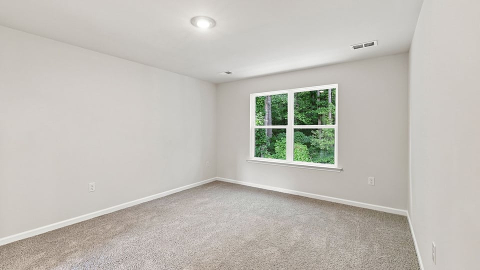 Bedroom with carpet and windows.