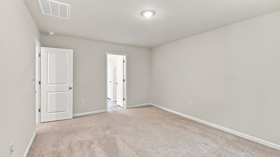 Bedroom with carpet and windows.