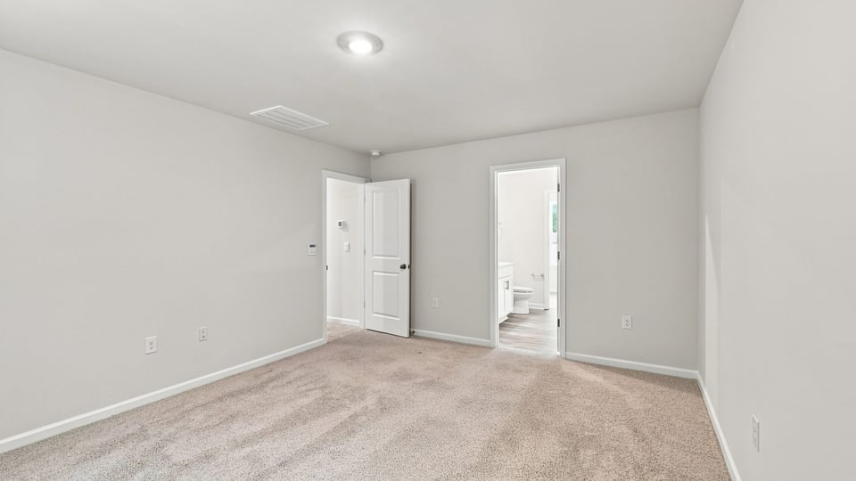 Bedroom with carpet and windows.