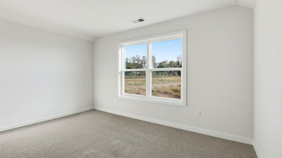Bedroom with carpet and window.