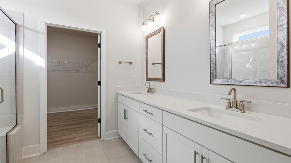 Bathroom with double vanity sink and walk in closet.