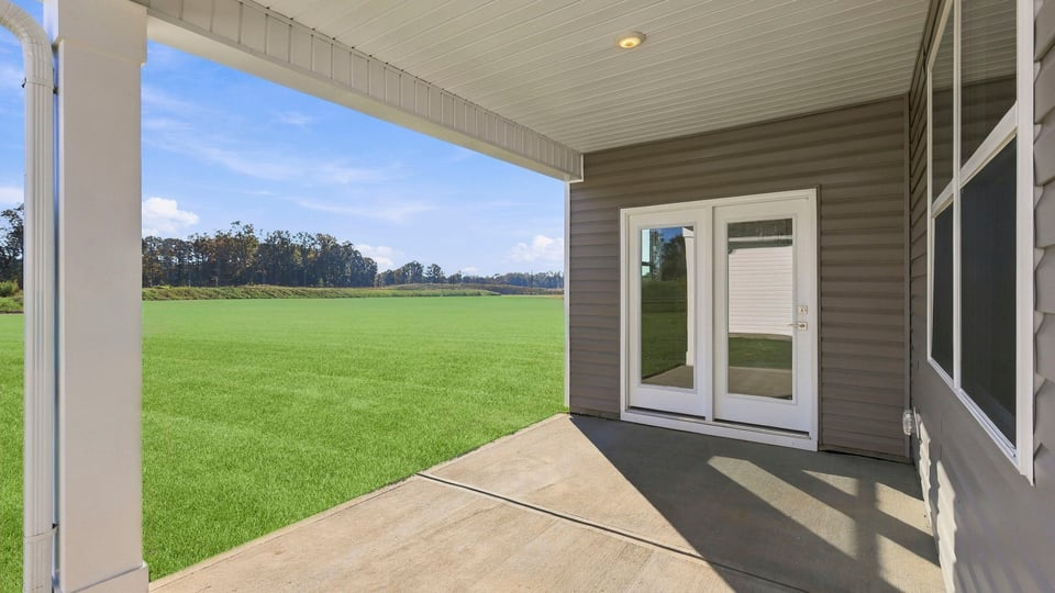 Back exterior of home with covered patio.
