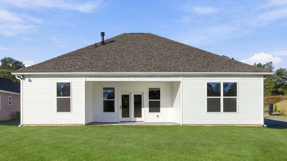 Back exterior of home with large backyard.