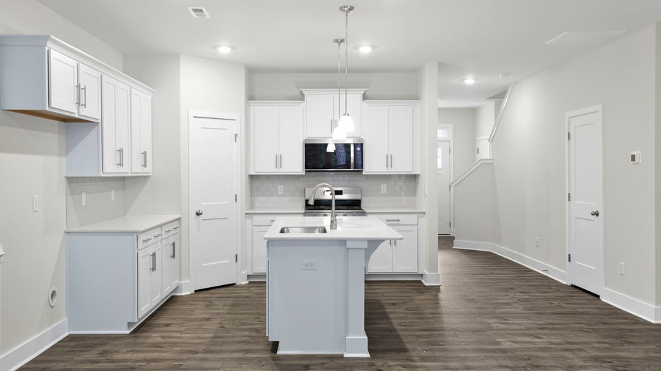 Kitchen and island with stainless steel appliances.
