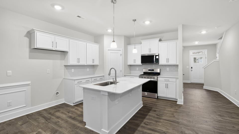 Kitchen and island with stainless steel appliances.