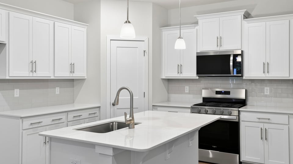 Kitchen and island with stainless steel appliances.