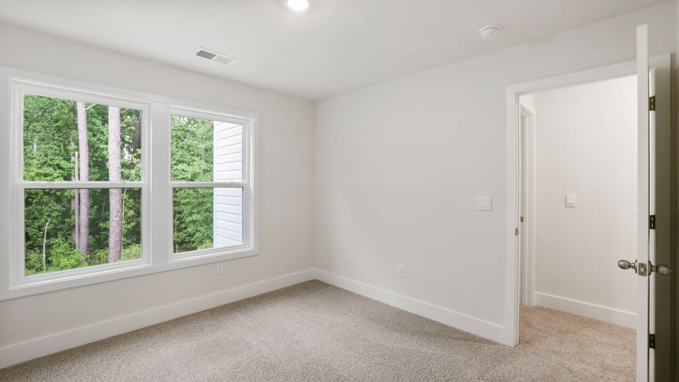 Bedroom with carpet and window.