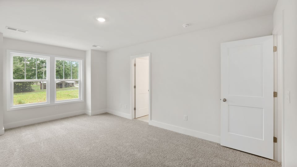 Bedroom with carpet and window.
