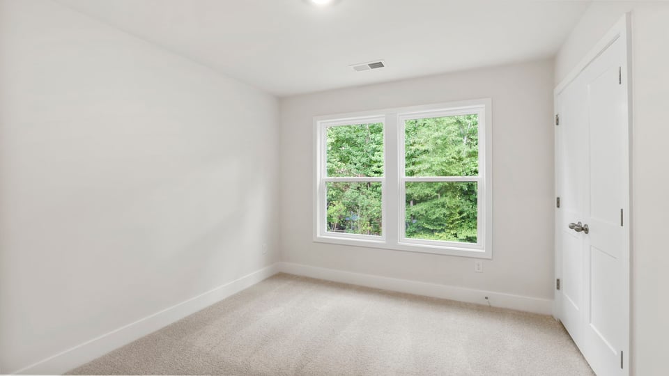 Bedroom with carpet and window.