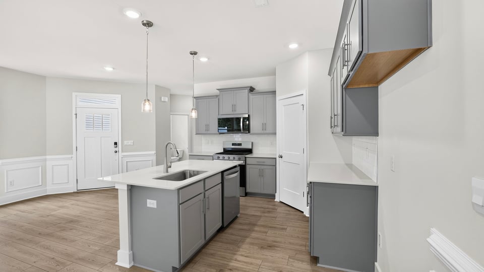 Kitchen and island with quartz countertops.