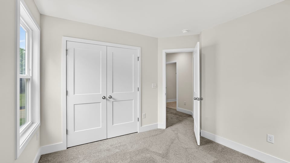 Bedroom with carpet and window.