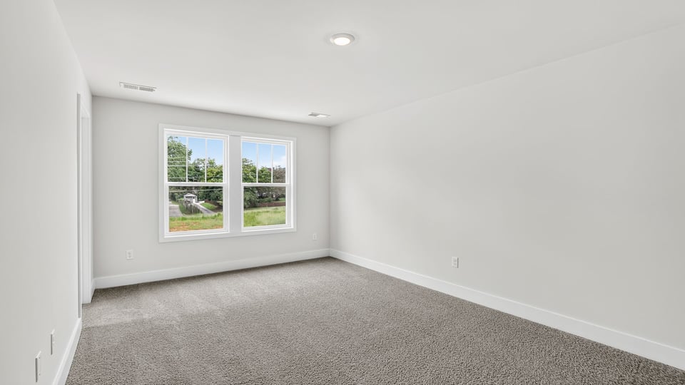 Bedroom with carpet and window.