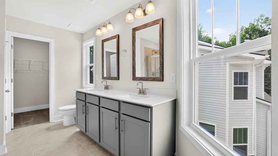 Bathroom with double vanity sink and walk in closet.