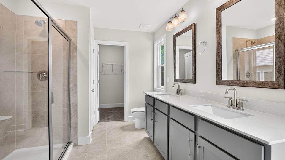 Bathroom with double vanity sink and walk in shower.