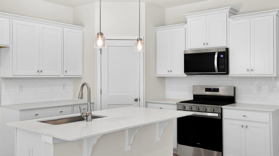 Kitchen and island with quartz counterops.