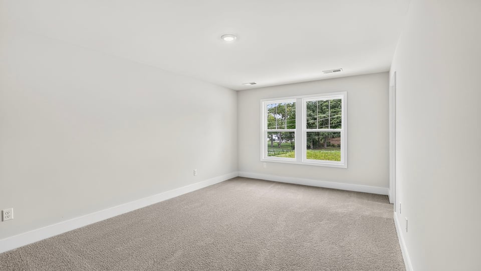 Bedroom with carpet and window.
