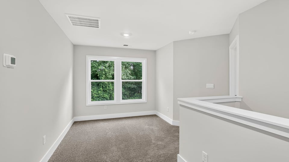 Loft area with carpet and window.