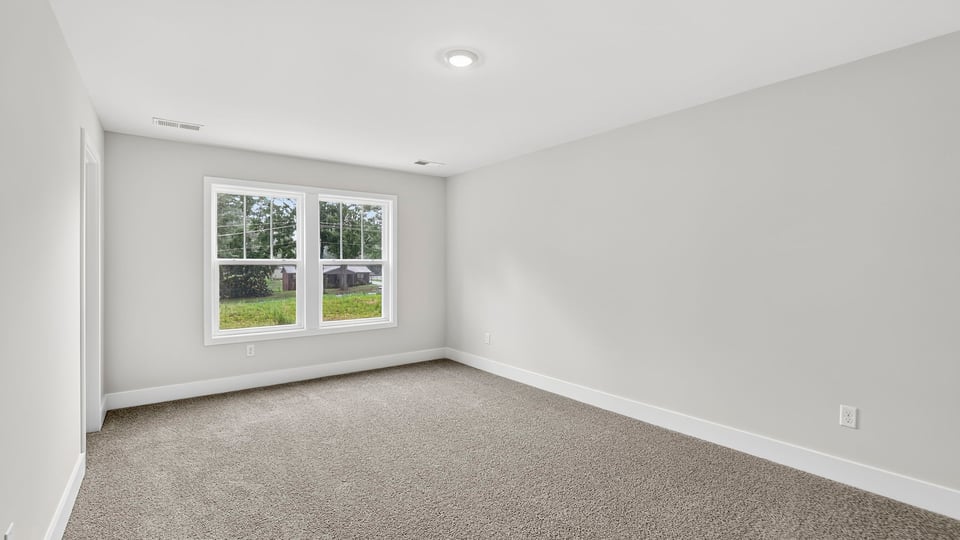 Bedroom with carpet and window.