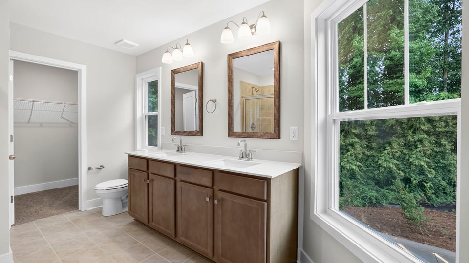 Bathroom with double vanity sink and walk in closet.