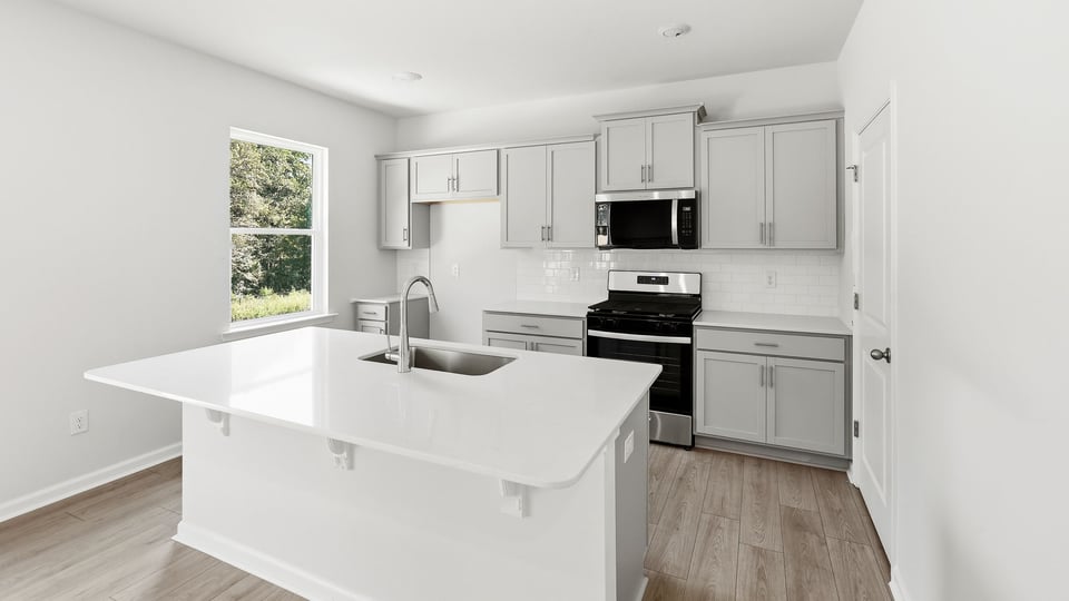 Kitchen and island with quartz countertops.