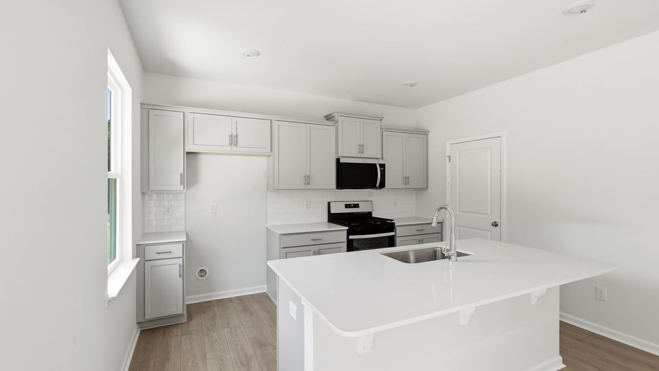 Kitchen and island with quartz countertops.