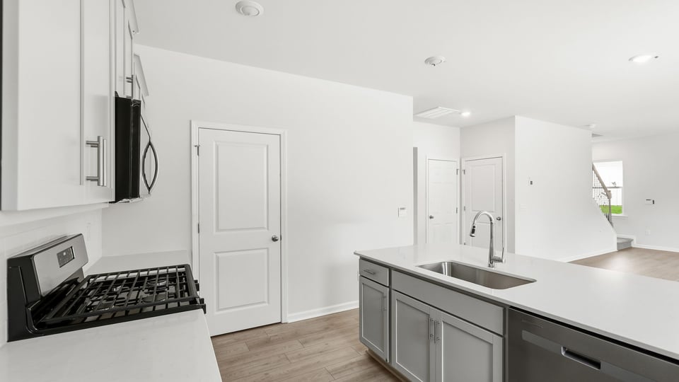 Kitchen and island with quartz countertops.