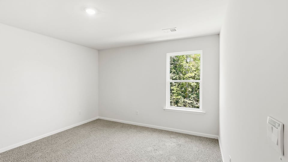 Bedroom with carpet and window.