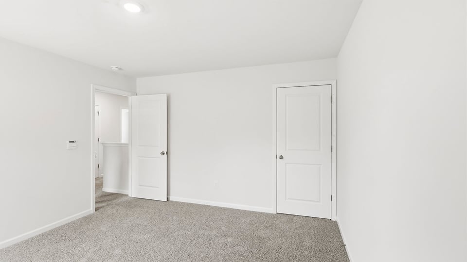 Bedroom with carpet and window.