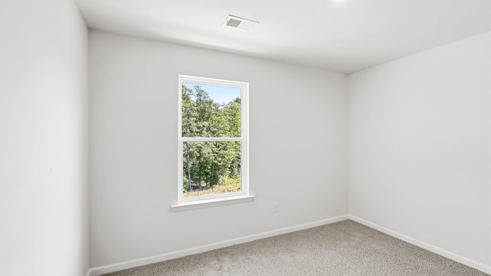 Bedroom with carpet and window.