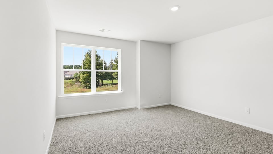 Bedroom with carpet and window.