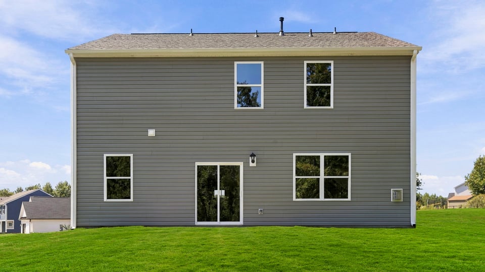 Back exterior of home with large backyard.