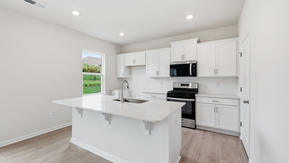 Kitchen and island with quartz countertops.