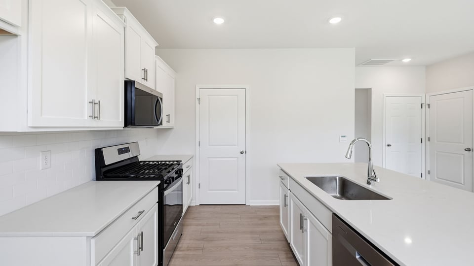 Kitchen and island with quartz countertops.