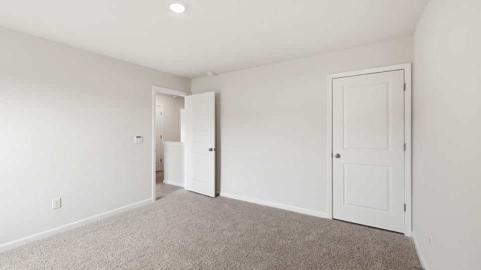 Bedroom with carpet and window.