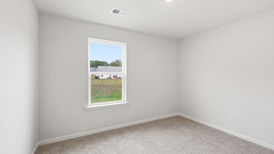 Bedroom with carpet and window.