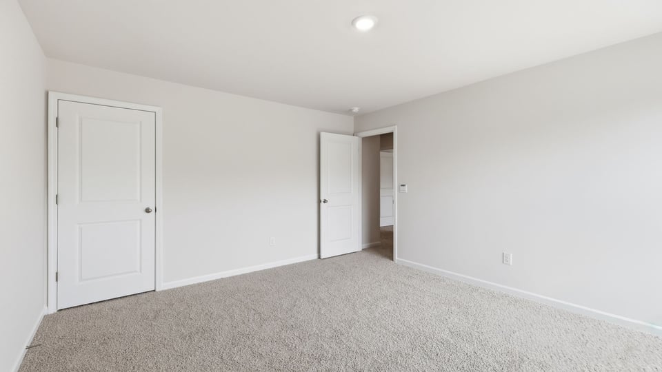 Bedroom with carpet and window.